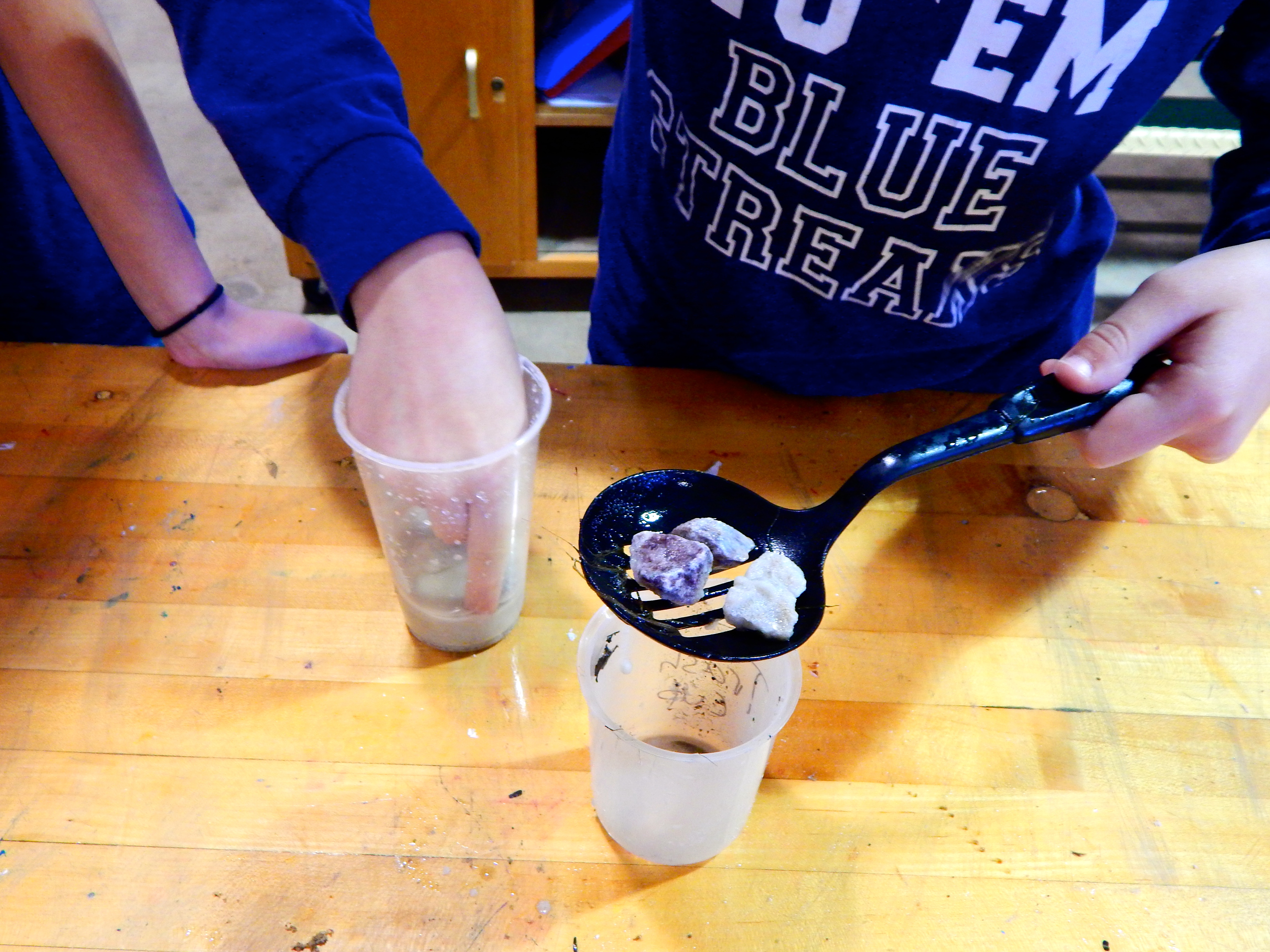 One student prepares to filter water through large rocks.